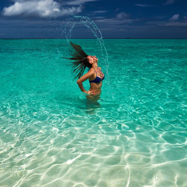 Mulher salpicando água com cabelo no oceano — Fotografia de Stock