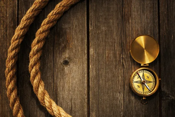 Antique compass and rope over wooden background — Stock Photo, Image