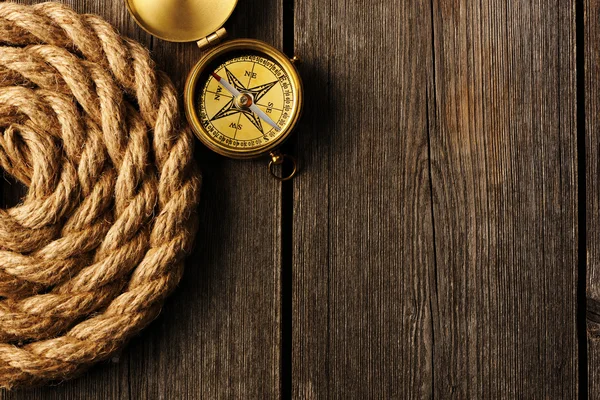 Starožitný kompas a lana přes dřevěné pozadí — Stock fotografie