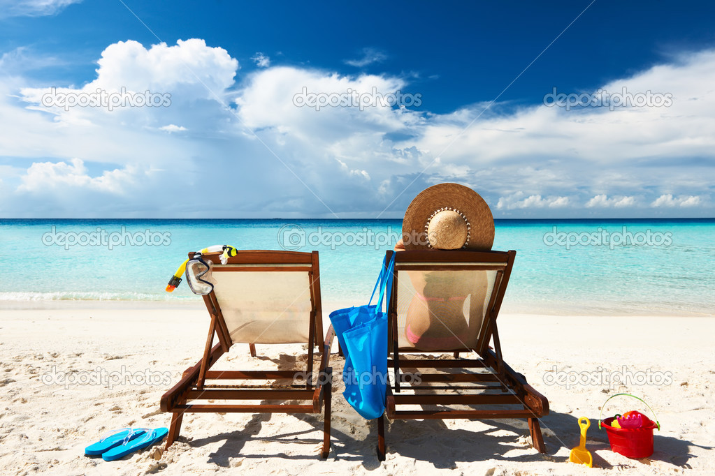 Woman on a tropical beach in chaise lounge