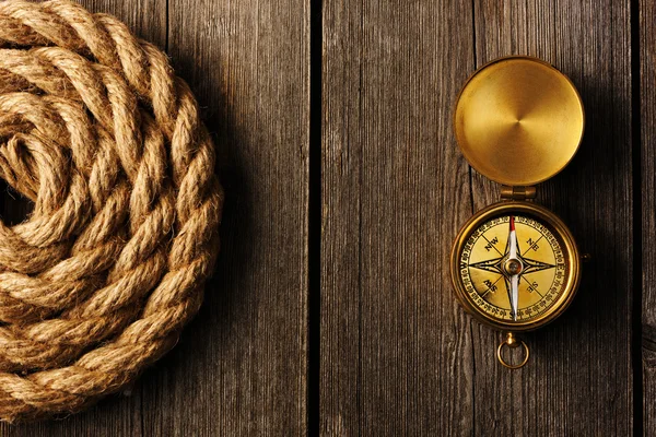 Antique compass and rope over wooden background — Stock Photo, Image