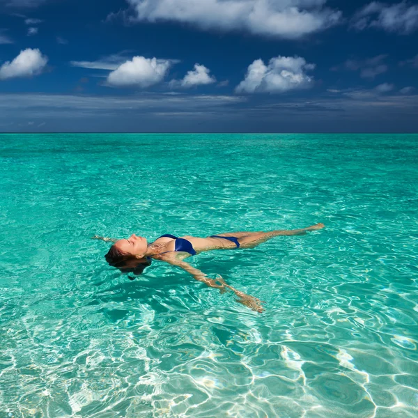 Donna in bikini sdraiata sull'acqua — Foto Stock