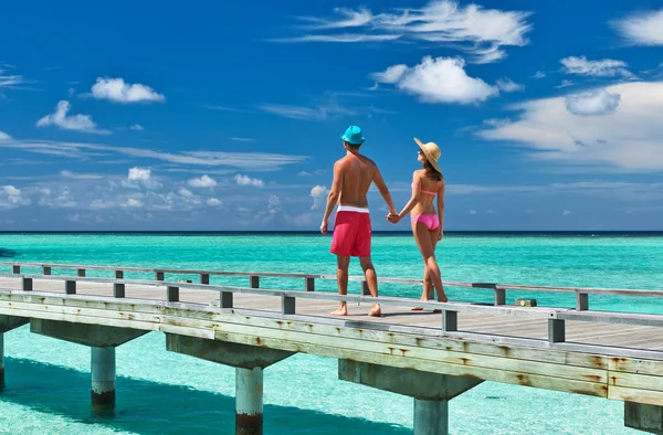 Casal em um molhe de praia em Maldivas Fotografias De Stock Royalty-Free