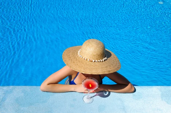 Vrouw bij zwembad met kosmopolitische cocktail — Stockfoto