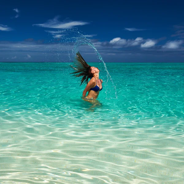 Mujer salpicando agua con pelo en el océano — Foto de Stock