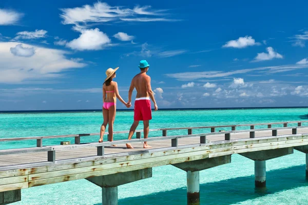 Casal em um molhe de praia em Maldivas Imagem De Stock