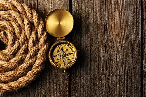 Antika kompass och rep över trä bakgrund — Stockfoto