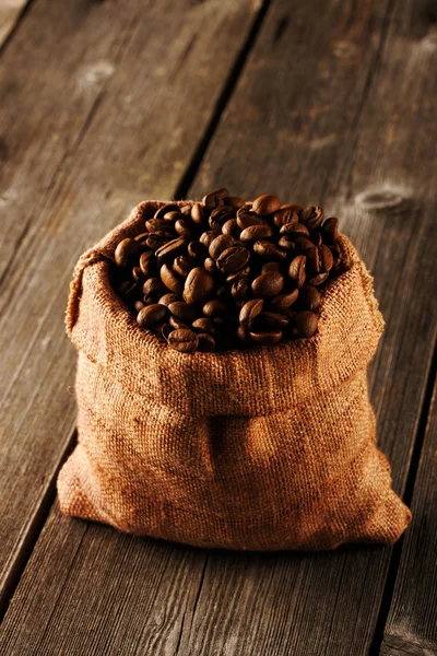 Granos de café en bolsa en la mesa — Foto de Stock