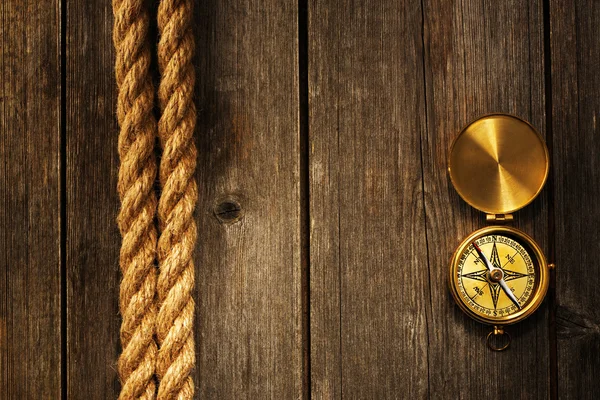 Antique compass and rope over wooden background — Stock Photo, Image