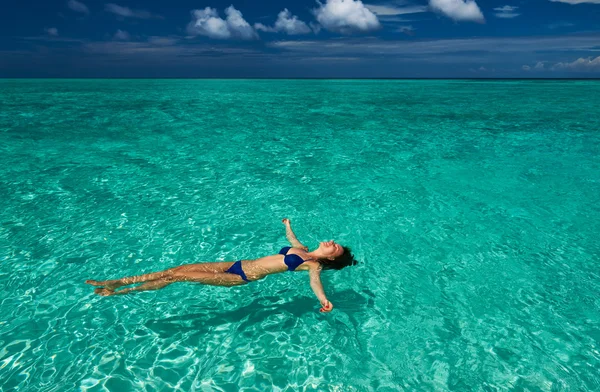 Vrouw in bikini liggend op water — Stockfoto