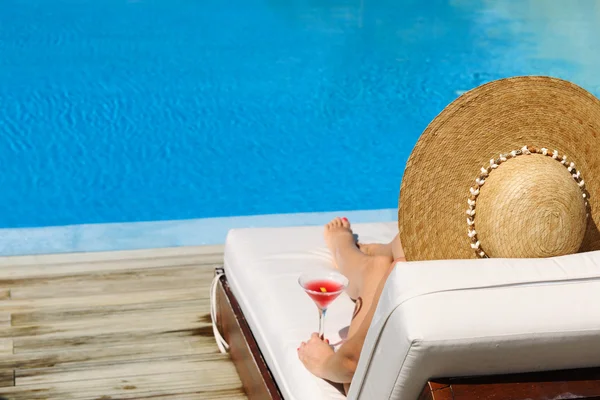 Femme au bord de la piscine avec cocktail cosmopolite — Photo