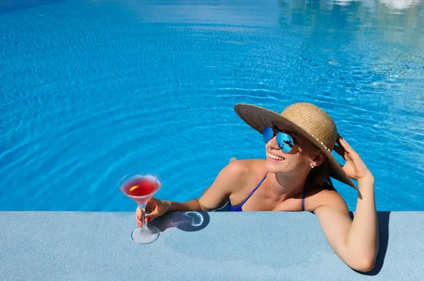 Donna a bordo piscina con cocktail cosmopolita — Foto Stock