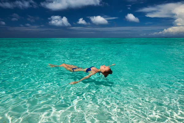 Mujer en bikini acostada en el agua — Foto de Stock