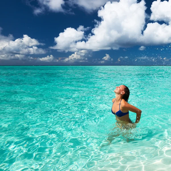 Vrouw opspattend water met haar in de Oceaan — Stockfoto