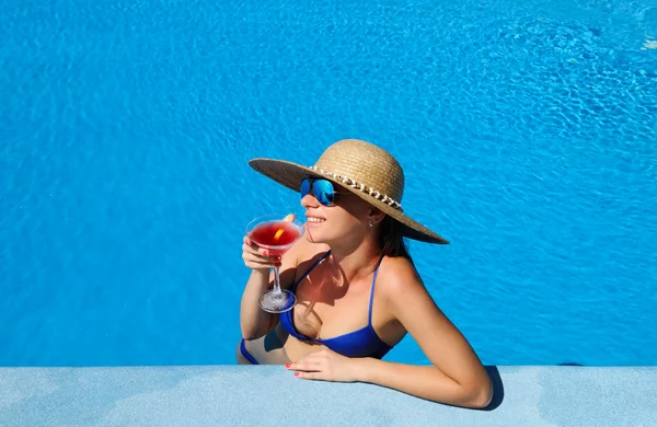 国際色豊かなカクテルを片手に、プールサイドでの女性 — ストック写真