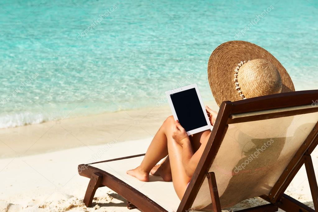 Young woman with tablet pc at the beach