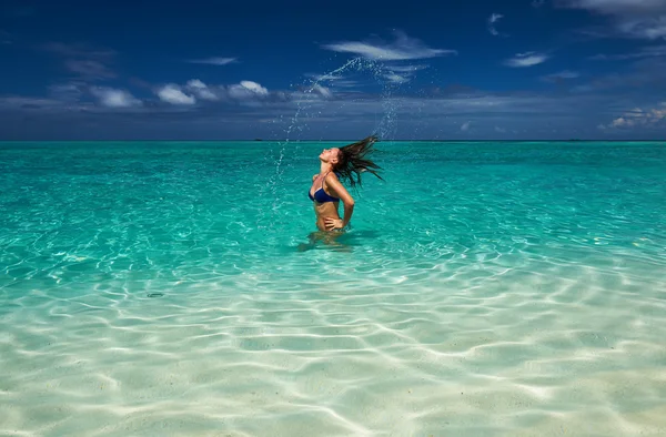 Kvinna stänkande vatten med hår i havet — Stockfoto