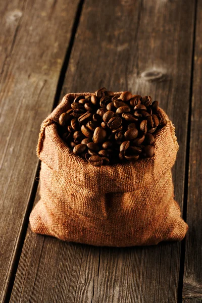 Granos de café en bolsa en la mesa — Foto de Stock