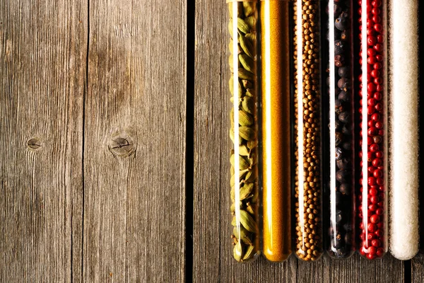 Przyprawy w zlewki na drewnianym stole — Zdjęcie stockowe