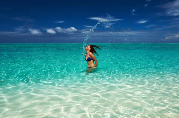 Mulher salpicando água com cabelo no oceano — Fotografia de Stock