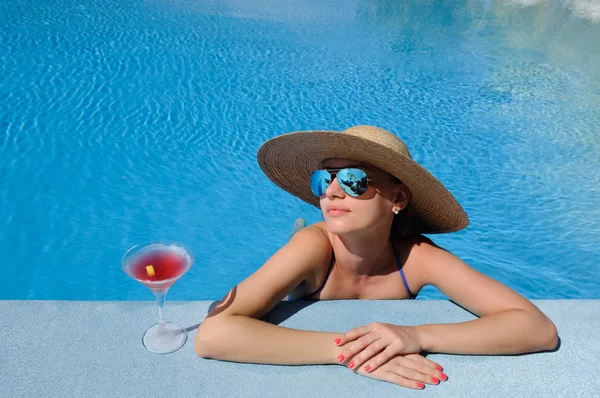 Mujer en la piscina con cóctel cosmopolita — Foto de Stock