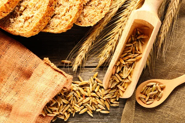 Roggen-Stacheln und Scheibenbrot auf Holzgrund — Stockfoto