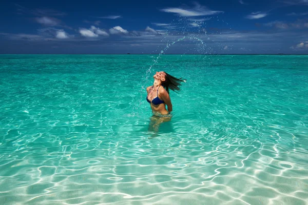 Woman splashing water with hair in the ocean Royalty Free Stock Images