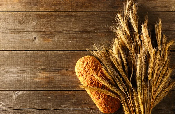 Ржаные шипы и хлеб на деревянном фоне — стоковое фото