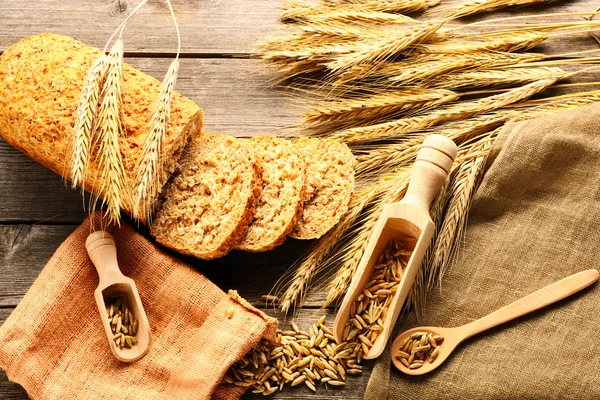 Roggen-Stacheln und Brot-Stillleben auf Holzgrund — Stockfoto