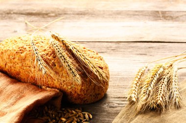 Çavdar spikelets ve ahşap zemin üzerine ekmek natürmort