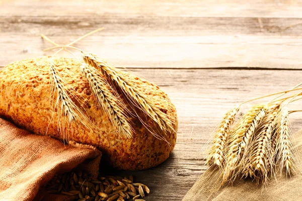 Roggen-Stacheln und Brot-Stillleben auf Holzgrund — Stockfoto