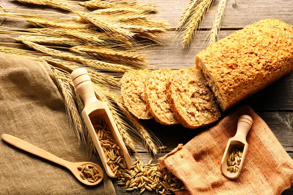 Espiguillas de centeno y pan bodegón sobre fondo de madera —  Fotos de Stock