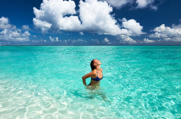 Mulher salpicando água com cabelo no oceano — Fotografia de Stock