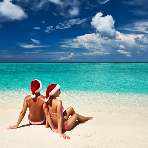 Pár v santa klobouk na pláži na Maledivy — Stock fotografie