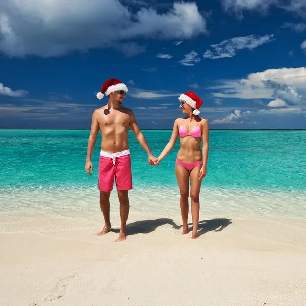 Para w kapelusz Świętego Mikołaja na plaży w Malediwy — Zdjęcie stockowe