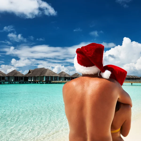 Casal no chapéu do Papai Noel em uma praia em Maldivas — Fotografia de Stock