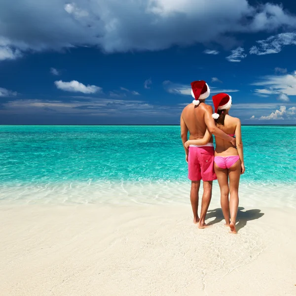 Pareja en sombrero de santa en una playa en Maldivas — Foto de Stock