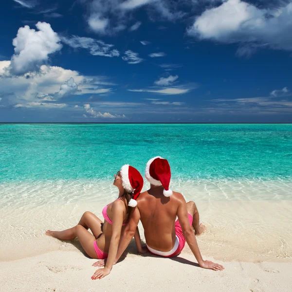 Casal no chapéu do Papai Noel em uma praia em Maldivas — Fotografia de Stock