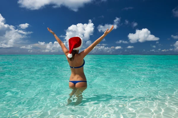 Mulher de chapéu de Papai Noel na praia — Fotografia de Stock