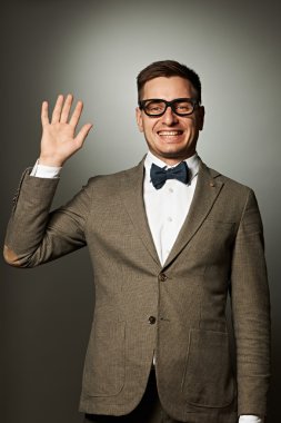 Nerd in eyeglasses and bow tie says Hello clipart