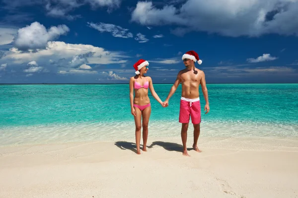Пара в шляпе Санты на пляже на Мальдивах — стоковое фото