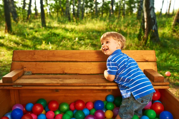 Mutlu çocuk renkli plastik toplarla oynuyor — Stok fotoğraf