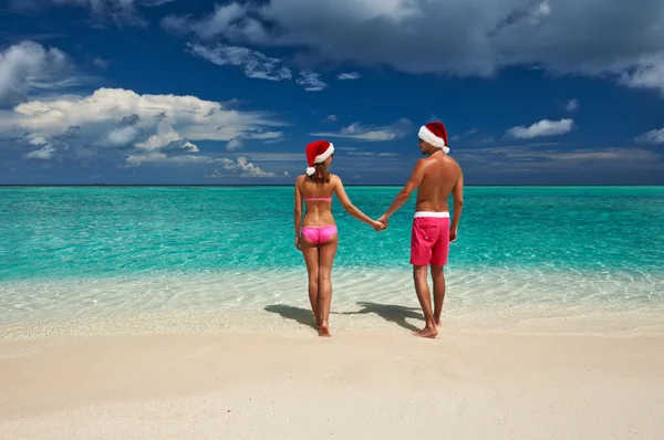 Noel Baba şapkalı bir plajda Çift — Stok fotoğraf