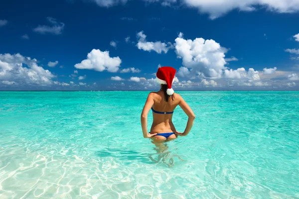 Donna in cappello di Babbo Natale in spiaggia — Foto Stock