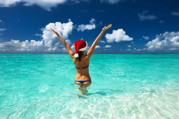 Mulher de chapéu de Papai Noel na praia — Fotografia de Stock