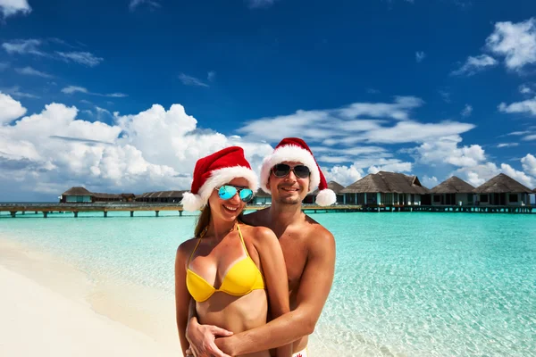 Pár v santa klobouk na pláži na Maledivy — Stock fotografie