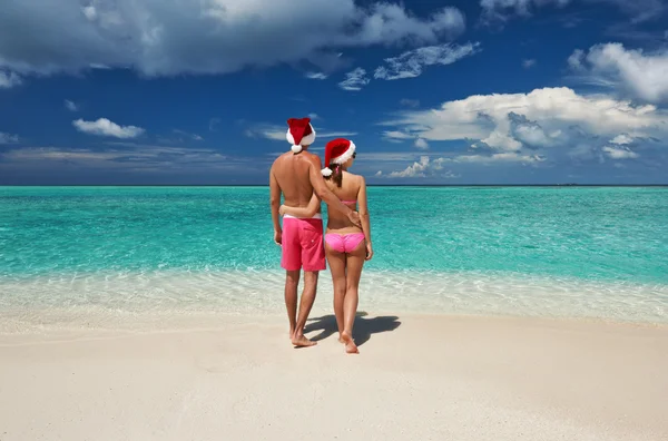 Pareja en sombrero de santa en una playa en Maldivas — Foto de Stock