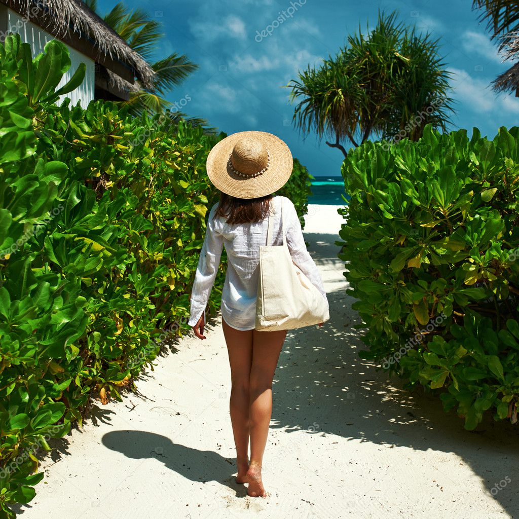 Woman with bag and sun hat going to beach