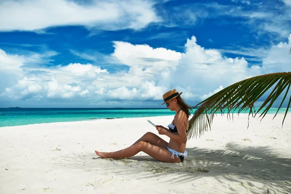 Vrouw met tablet pc op het strand — Stockfoto