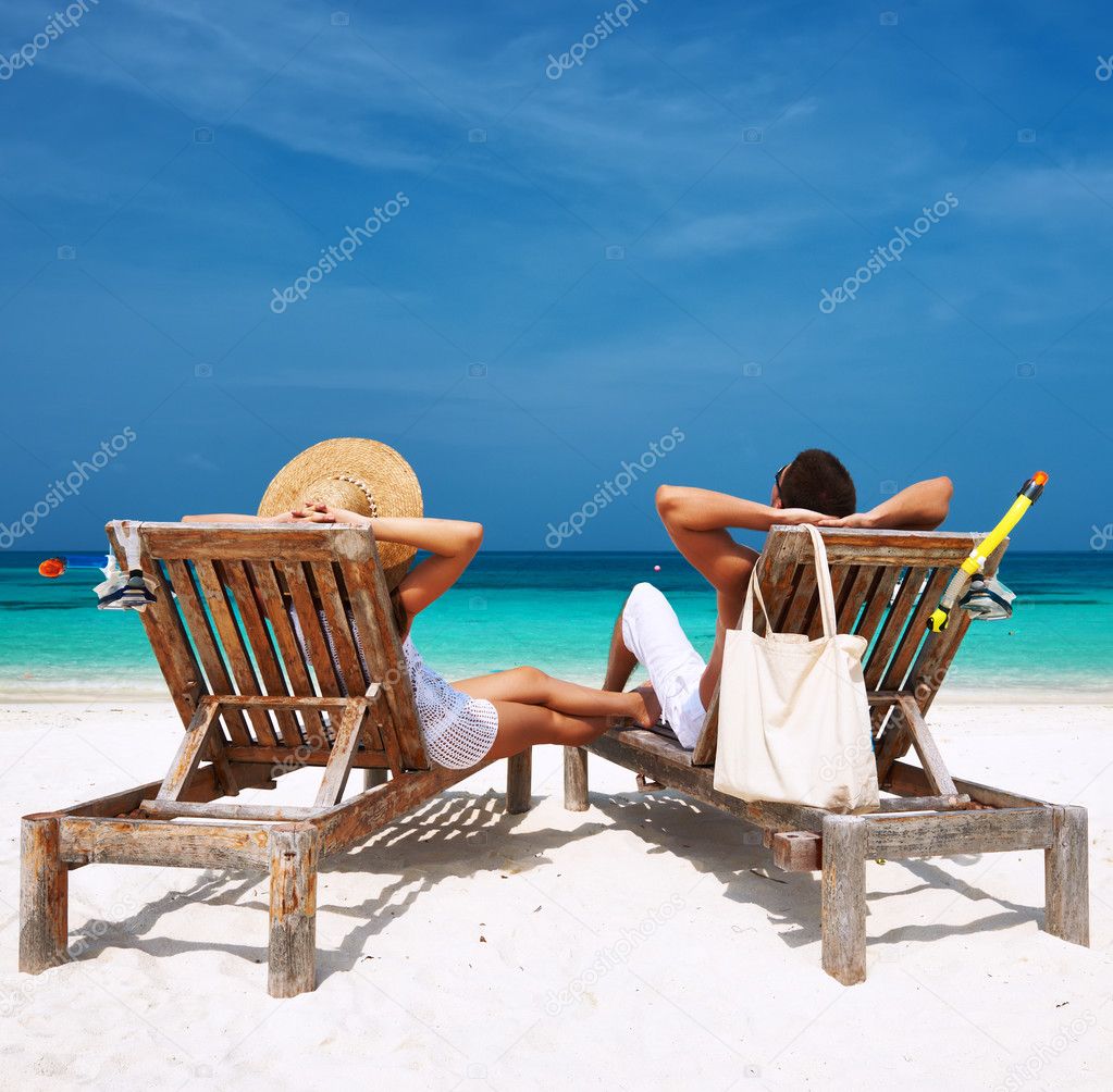 Couple in white relax on a beach at Maldives